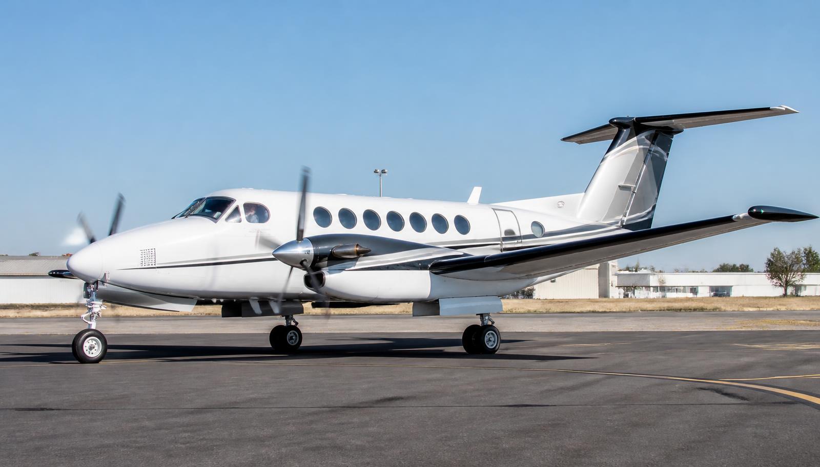 King Air taxiing on an airport taxiway in daylight